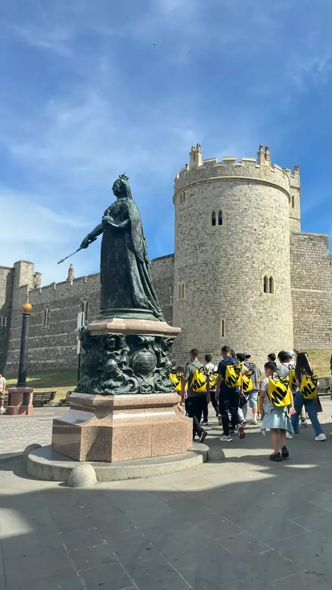 Windsor Kalesi önünde Kraliçe Victoria heykeli ve öğrenciler