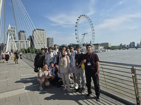 Golden Jubilee Köprüsü'nde, arkada London Eye ile toplu fotoğraf