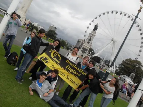 London Eye önünde çimenlikte pankartla poz veren öğrenciler