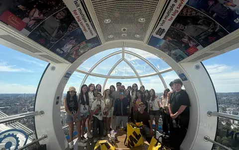 London Eye kapsülünde pankartla grup fotoğrafı